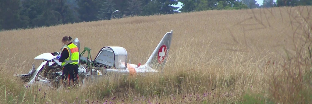 Eine Polizistin steht vor dem Flugzeug-Wrack, in dem der Gründer der Bäckereikette „Lila Bäcker“ starb. Er war aus 40 Meter Höhe abgestürzt. 