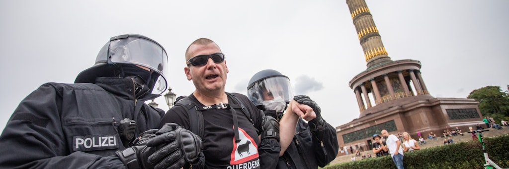 Ein Mann wird bei einem Protest gegen die Corona-Maßnahmen vor der Siegessäule von Polizisten abgeführt.