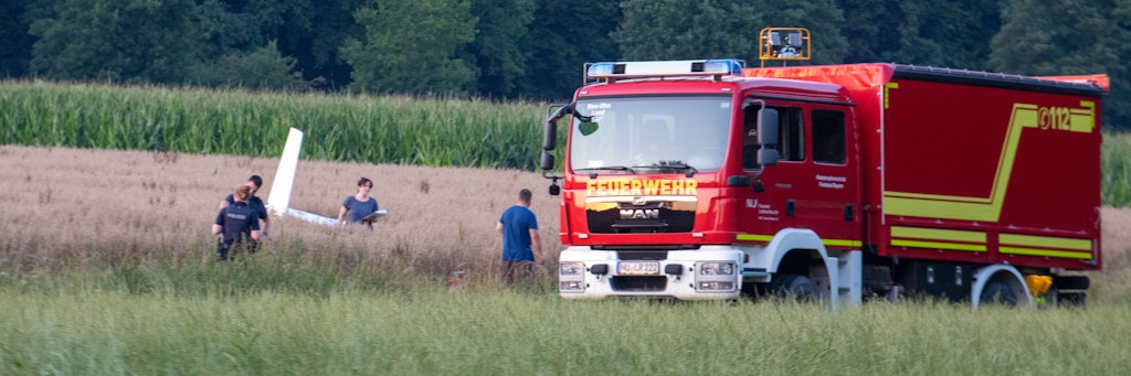 Einsatzkräfte arbeiten an der Absturzstelle von einem Kleinflugzeug in einem Getreidefeld. 
