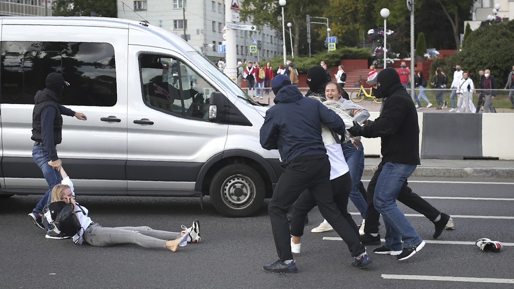 Sicherheitskräfte nehmen Demonstrantinnen fest und zerren sie in einen Transporter.