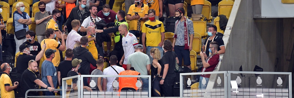 Toni Leistner (weißes Trikot) klettert zurück in den Innenraum in Dresden, nachdem er zuvor Stress mit einem Dynamo-Fan hatte. 
