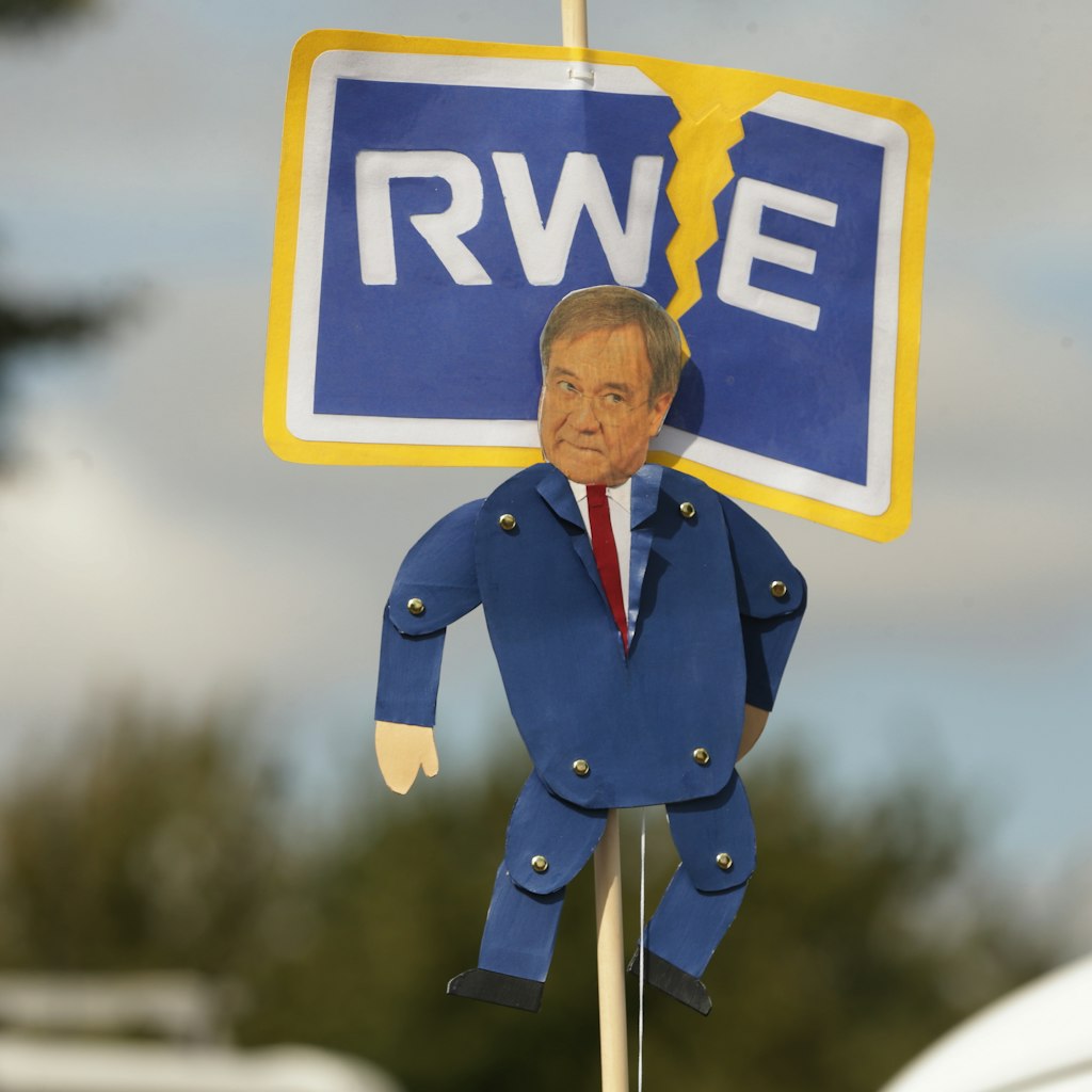 Bei einer Demo wird Laschet als Marionette des Energie-Riesen RWE dargestellt.