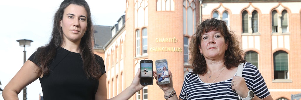 Ilka Ritter und Tochter Jessica vor dem Bettenhaus der Charité, wo Oliver Ritter um sein Leben kämpft. Mutter und Tochter zeigen Fotos von früher, als der Familienvater noch fit und gesund war.
