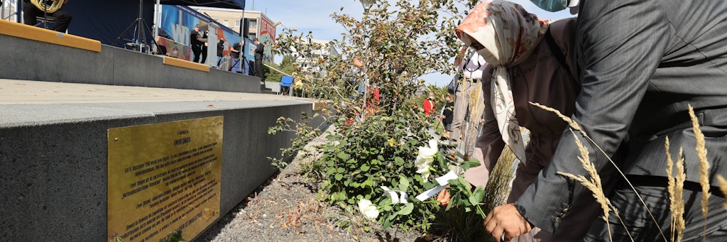 Adile Şimşek, die Witwe des ermordeten Enver Şimşek, legt zusammen mit ihrem Sohn Blumen an einer Gedenktafel für das erste NSU-Opfer ab. 