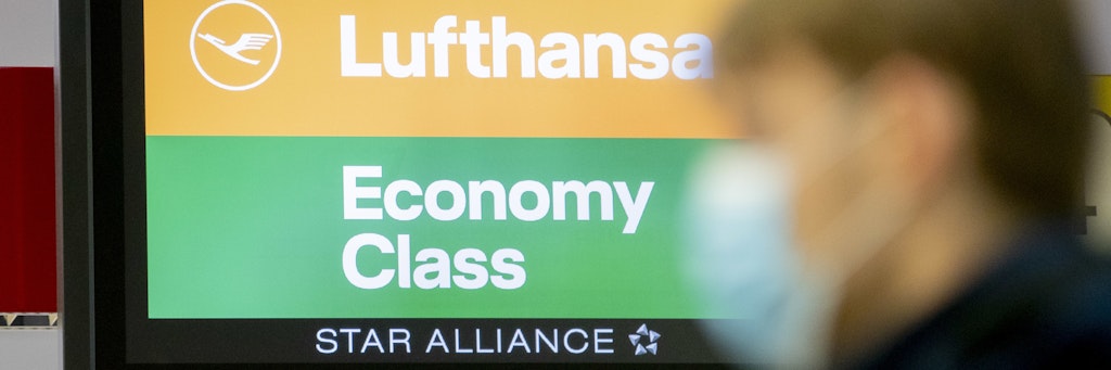 Ein Mann trägt am Flughafen einen Mund-Nasen-Schutz.