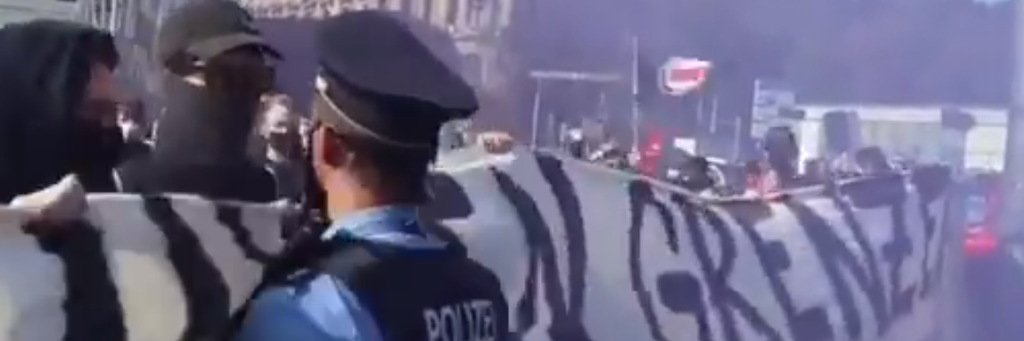 Der Polizeiführer steht vor der Menge, dann fällt der Satz: „Schubs mich und du fängst dir ‘ne Kugel“.