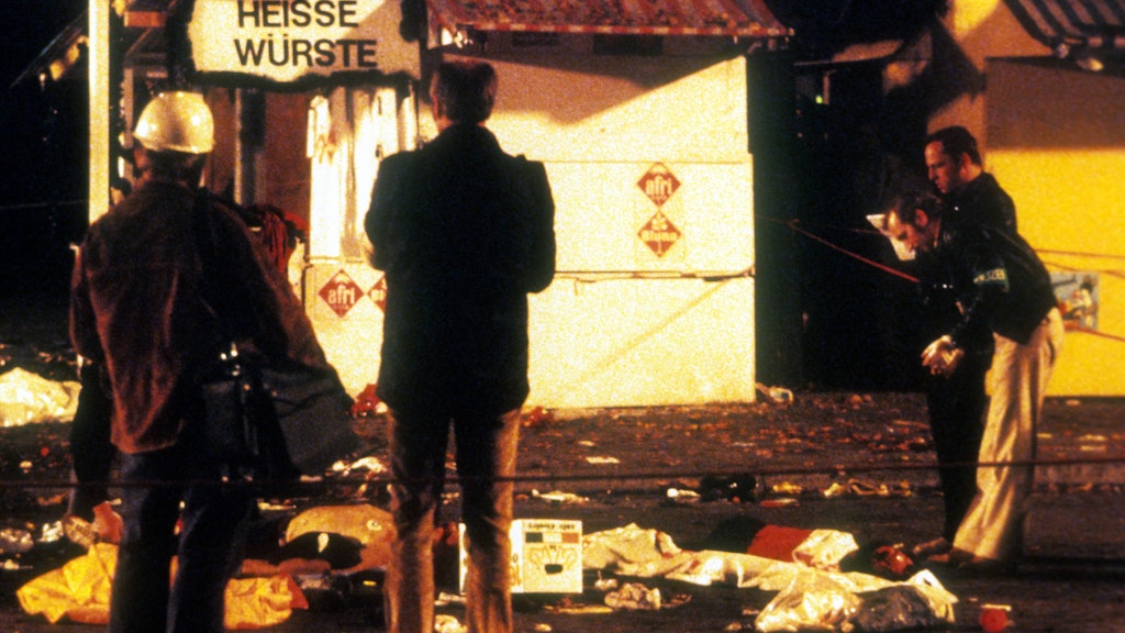 Vor einem Würstchenstand auf dem Oktoberfest 1980 sichern Polizisten Spuren.