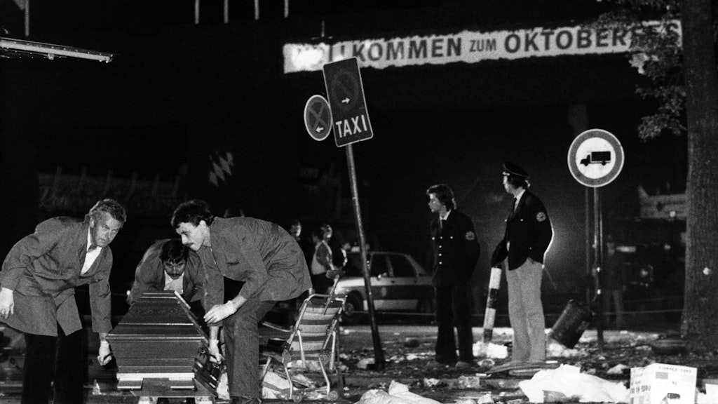 Ein Sarg wird vom verwüsteten Tatort beim Oktoberfest weggetragen.