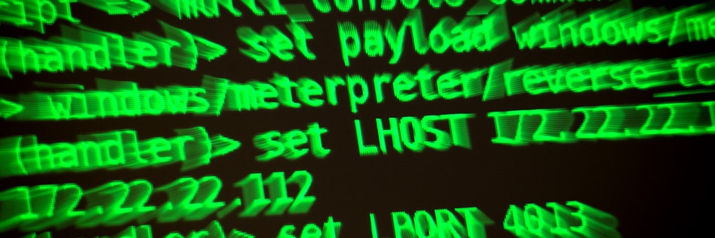 Buchstaben und Zahlen leuchten auf einem Bildschirm, auf dem ein Hacker-Programm geöffnet ist. 