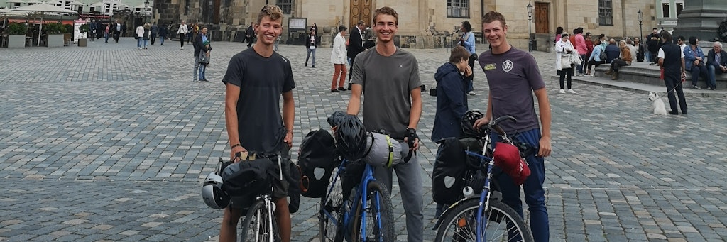 Die drei Kölner Abiturienten Anton, Lovis und Till stehen mit ihren Fahrrädern vor der Dresdener Frauenkirche.