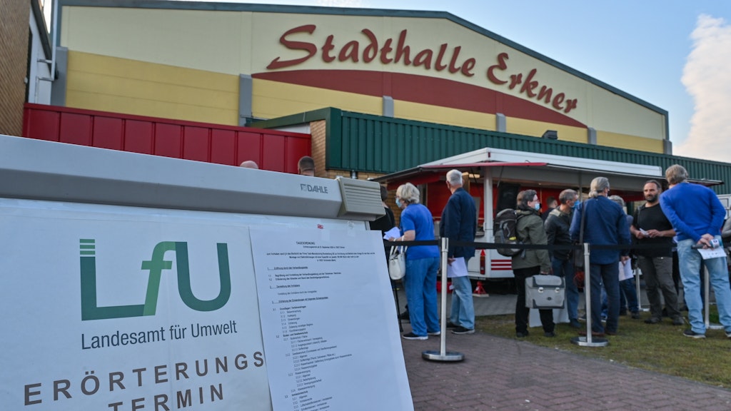Die Tesla-Kritiker warten vor der Stadthalle Erkner auf Einlass zur Anhörung.
