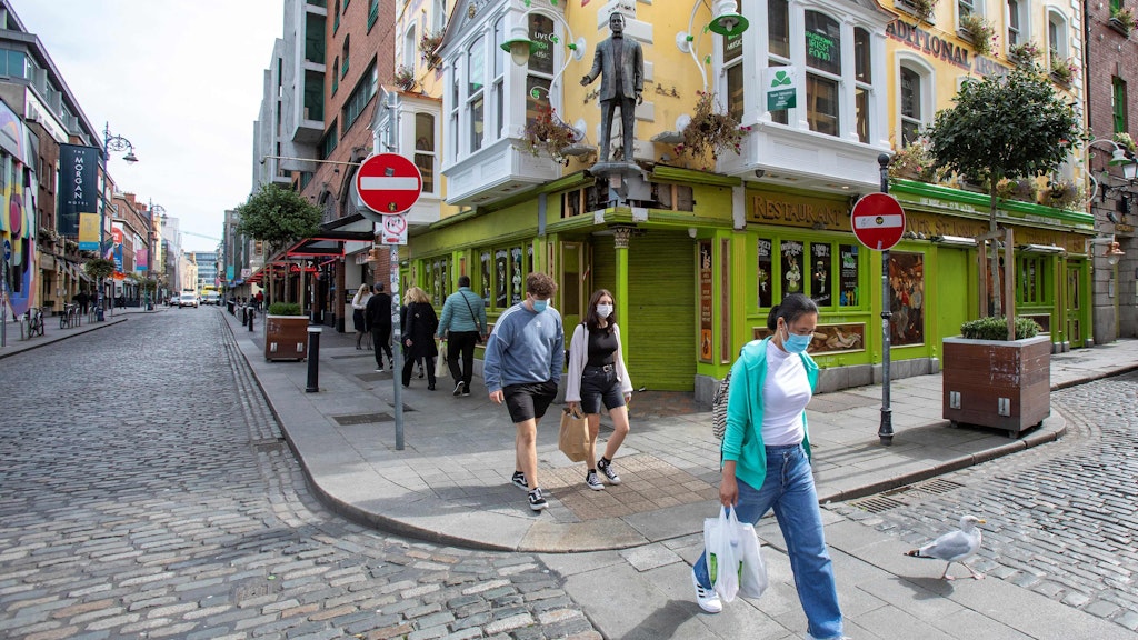 Passanten laufen mit Mundschutz durch die Innenstadt von Dublin. Auch die irische Hauptstadt ist zum Risikogebiet erklärt worden.