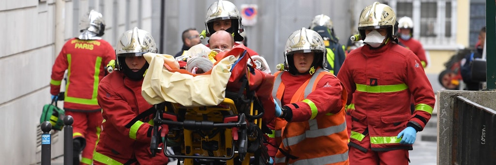Einsatzkräfte der Feuerwehr schieben nach dem Messerangriff eine Trage mit einem Verletzten.