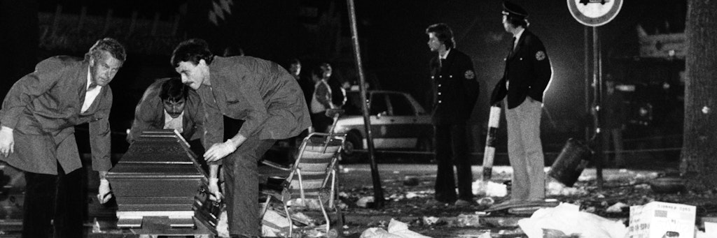 Ein Sarg wird vom verwüsteten Tatort beim Oktoberfest weggetragen. Am 26. September 1980 hatte der Attentäter in einem Papierkorb eine Bombe deponiert.