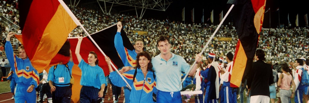 Arm in Arm ziehen die Fahnenträger Gabriele Lippe aus der Bundesrepublik und Ulf Timmermann aus der DDR am 1. September 1990 während der Schlußfeier der Leichtathletik-Europameisterschaft im jugoslawischen Split in das Stadion ein.