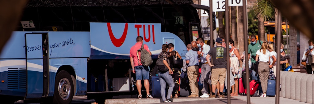 Teneriffa: Touristen mit Mundschutz holen ihr Gepäck aus einem Bus des Tourismuskonzerns Tui.