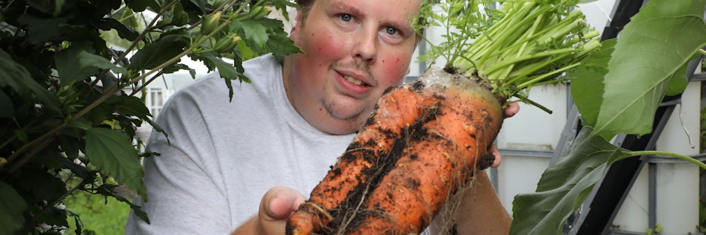 Patrick Teichmann zeigt eine von ihm gezüchtete Riesenmöhre. Der Thüringer hat die weltweit größte Vielfalt an XXL-Gemüse in seinem Schrebergarten.