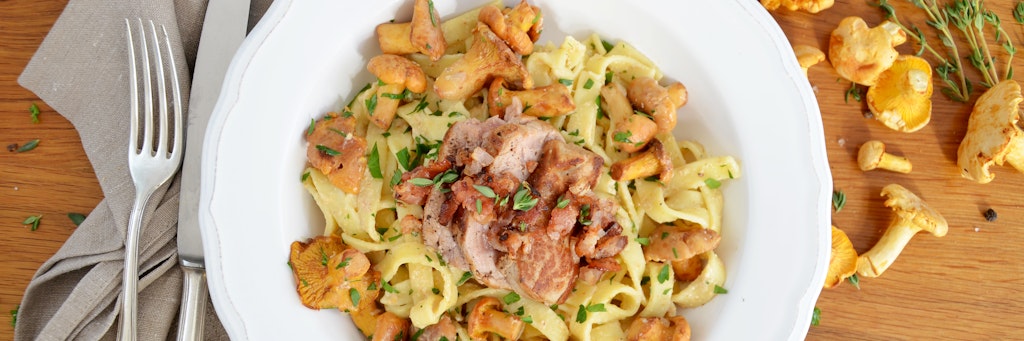 Pfifferlinge werden hier zusammen mit Tagliatelle, Schweinefilet und Bacon serviert.