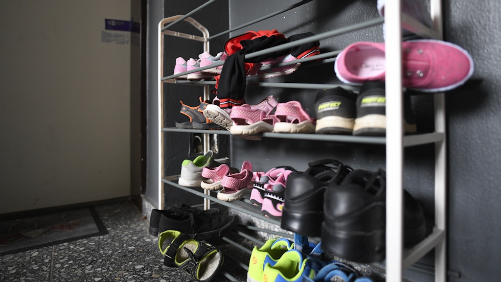 Kinderschuhe liegen in einem Schuhregal vor der Tür der Wohnung, in der die fünf Kinder starben.
