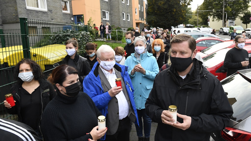 Oberbürgermeister Tim Kurzbach (r) hält eine Kerze in den Händen. 
