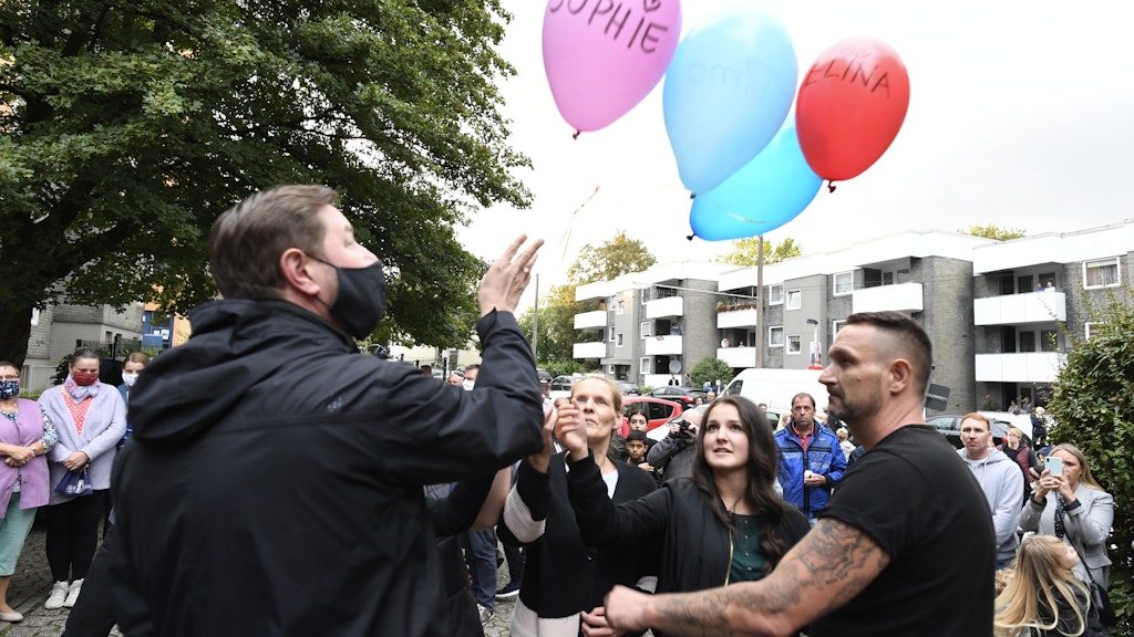 05.09.2020, Nordrhein-Westfalen, Solingen: Zusammen mit Oberbürgermeister Tim Kurzbach (l) lassen Nachbarn als Ausdruck ihrer Trauer fünf Luftballons mit den Namen der fünf getöteten Kinder steigen. 