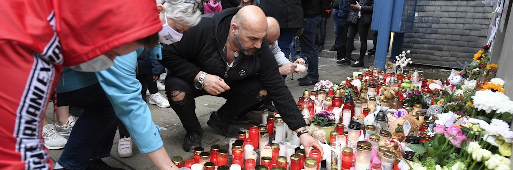 Nachbar Kasim Ayten legen Plüschtiere, Blumen und Kerzen vor dem Haus nieder, in dem fünf Kinder tot aufgefunden worden sind. 