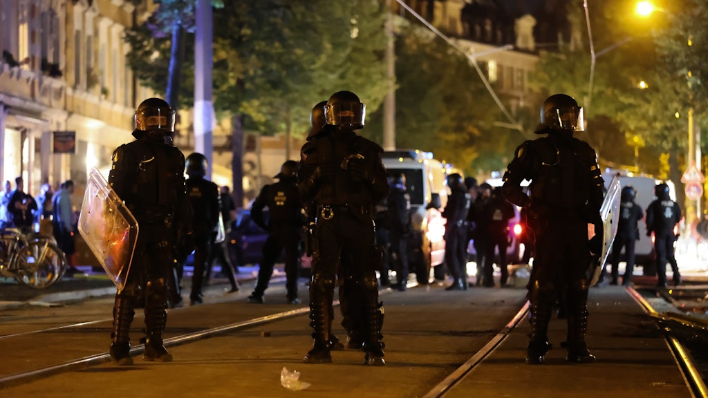 Bereitschaftspolizisten stehen auf einer Straße, als Demonstranten gegen die Räumung eines besetzten Hauses protestieren.