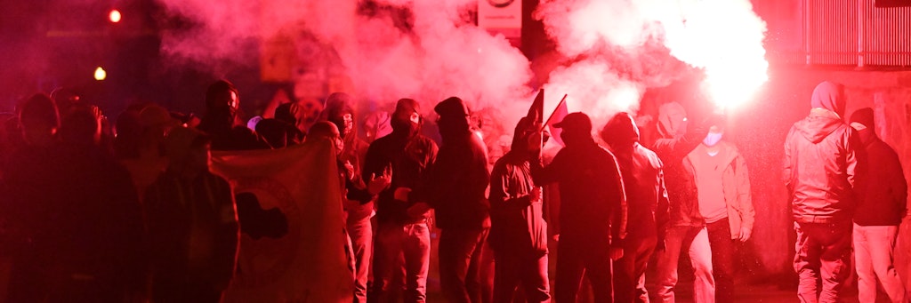 Eine Demo zieht mit roten Pyro-Fackeln durch den Stadtteil Connewitz.