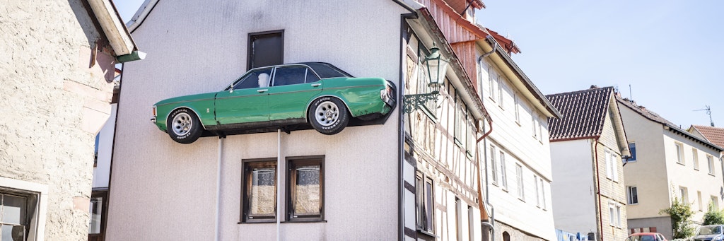 An der Fassade wurde ein alter, längs aufgeschnittener Ford Granada auf zwei Stützen angebracht. 