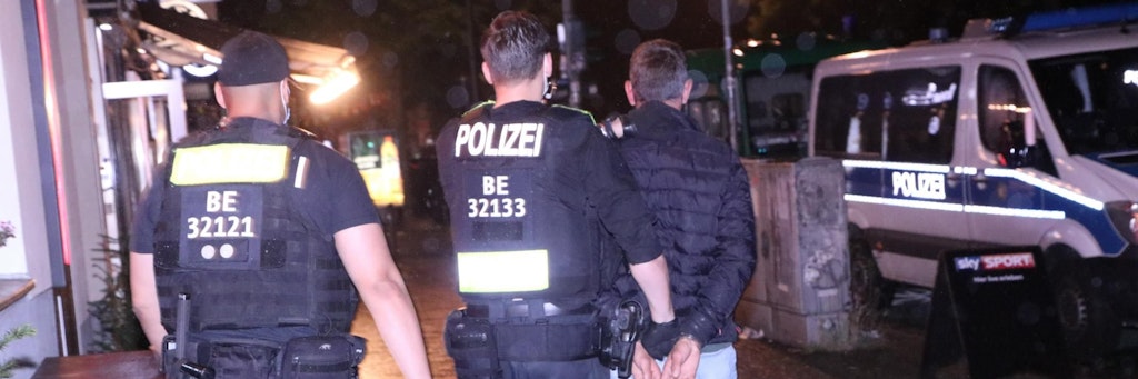 Ein mit Haftbefehl Gesuchter wird während der Razzia in Neukölln abgeführt.