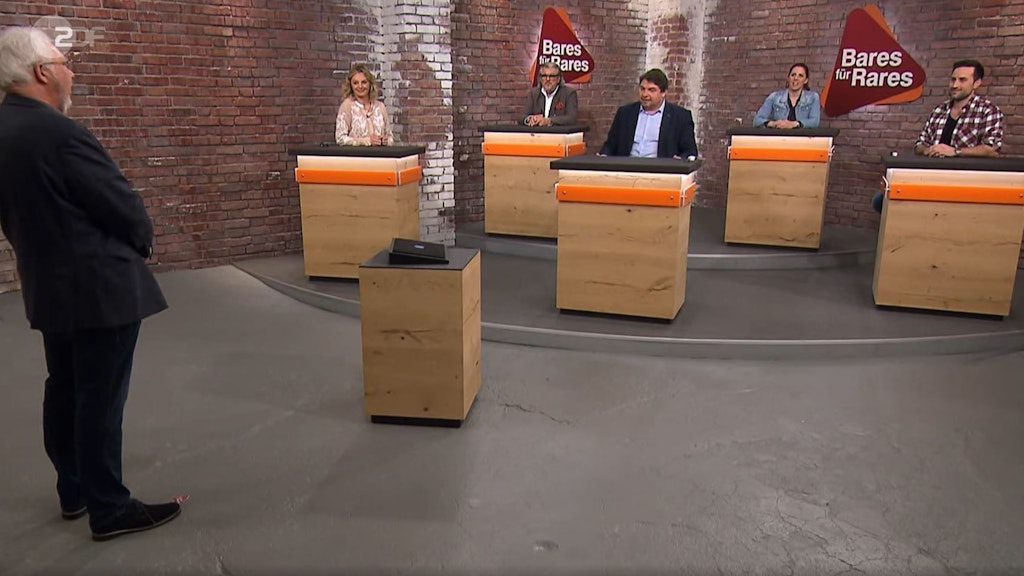 Wilfried Seger zeigt seine Münze im Bares für Rares-Händlerraum vor.