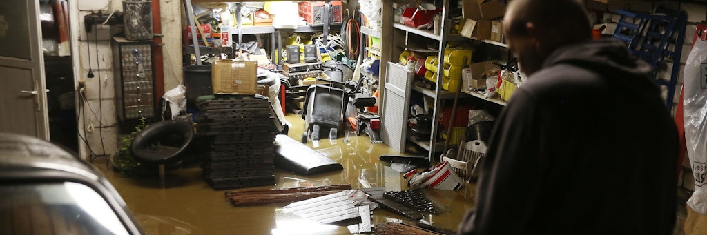 Ein Hausbesitzer steht in seiner überfluteten Garage.