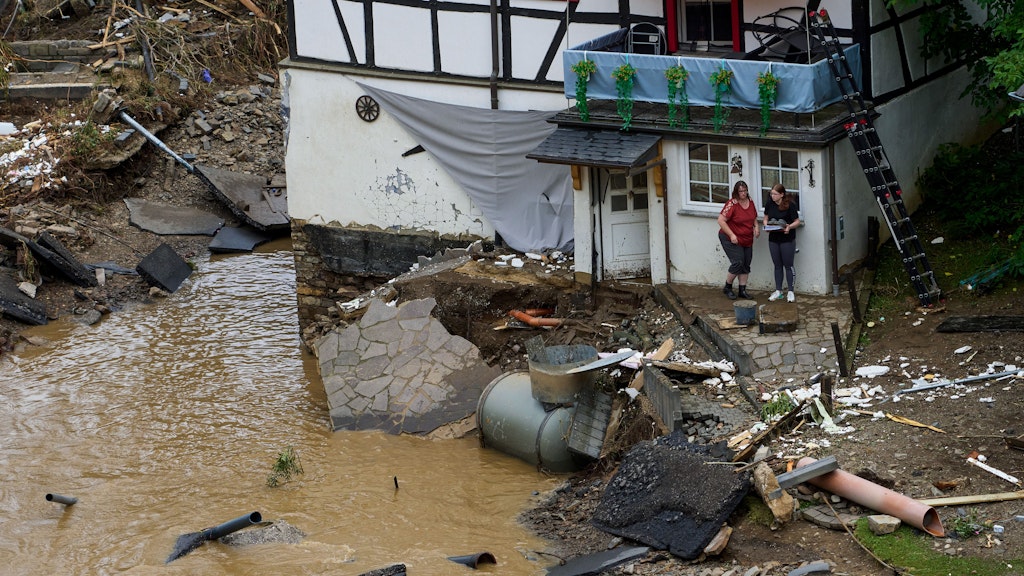 Zwei Frauen stehen neben Trümmern vor einem Haus in dem Ort im Kreis Ahrweiler am Tag nach dem Unwetter. 