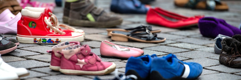 Bei einer Schweigeaktion für die „Kinder von Lügde“ stehen Kinderschuhe auf dem Boden.