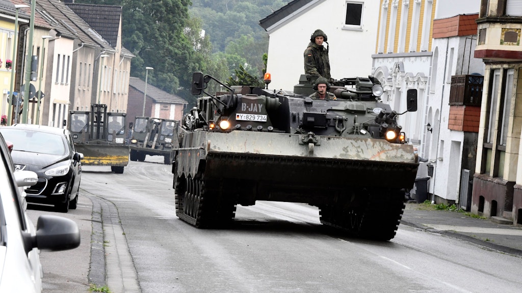 Nordrhein-Westfalen, Hagen: Mit einem Bergepanzer und schwerem Räumgerät rückt die Bundeswehr an, um die Schäden, die die Überflutung des Nahmerbach am Vorabend mit sich gebracht hatte, zu beseitigen.