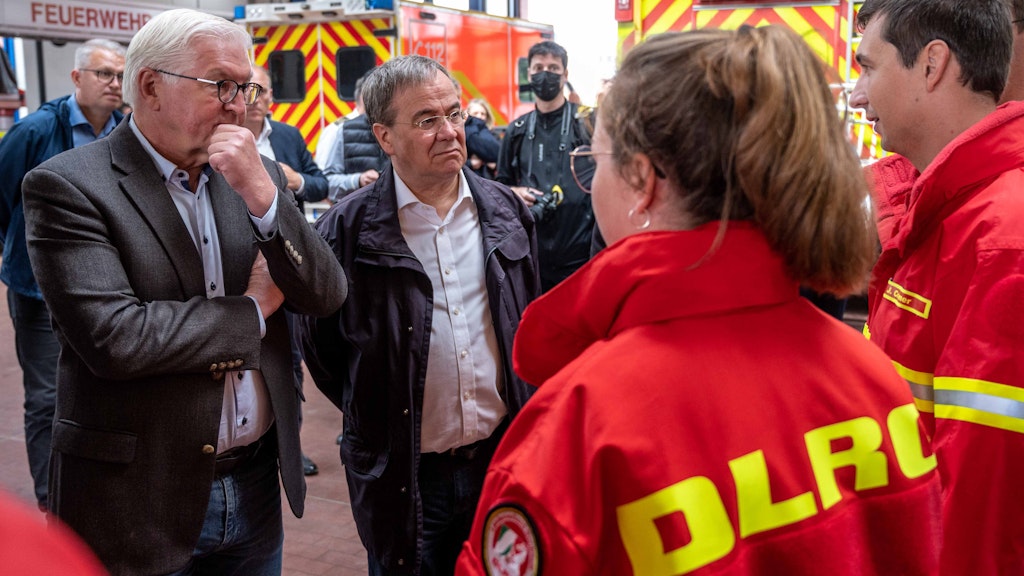 Bundespräsident Frank-Walter Steinmeier (l.) und Armin Laschet (CDU), Ministerpräsident von Nordrhein-Westfalen, unterhalten sich bei einem Besuch der Feuerwehrleitzentrale in Erftstadt mit Helfern.
