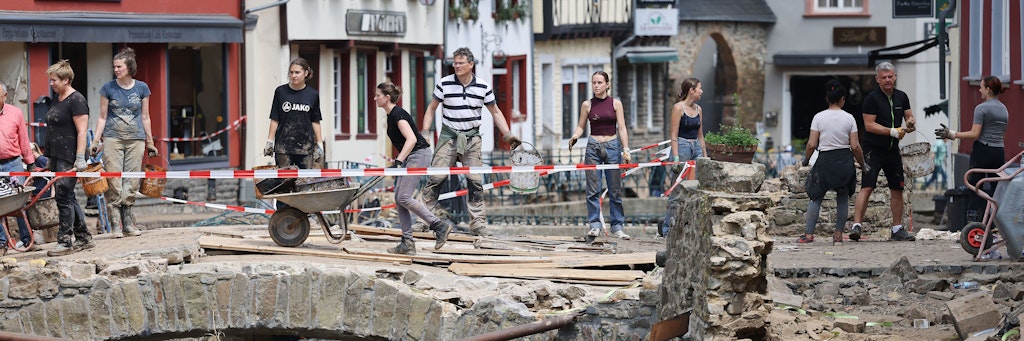 Menschen räumen in Bad Münstereifel Schutt beiseite. Das Städtchen in Nordrhein-Westfalen wurde vom Hochwasser stark getroffen.