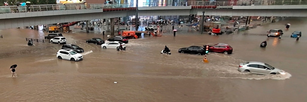 Fahrzeuge stehen in der zentralchinesischen Provinz Henan auf einer überfluteten Straße. 
