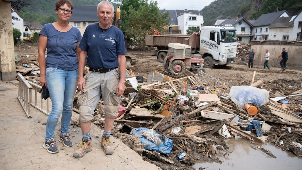 Umgeben von Schutt und Treibgut stehen Maria und Wolfgang Günzel in Altenahr an ihrem Haus.