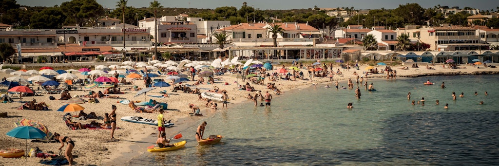 Urlauber kühlen sich am Strand Punta Prima in Sant Lluis. Seit Ende Juni sind die Corona-Zahlen praktisch überall in Spanien rapide in die Höhe geschossen. Foto: +++ dpa-Bildfunk +++