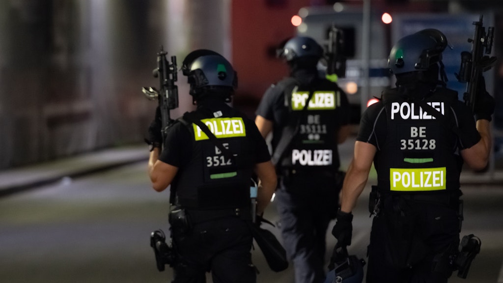 Polizisten mit Maschinenpistolen suchen auf dem Gelände eines Baumarktes in Wedding nach Verdächtigen.