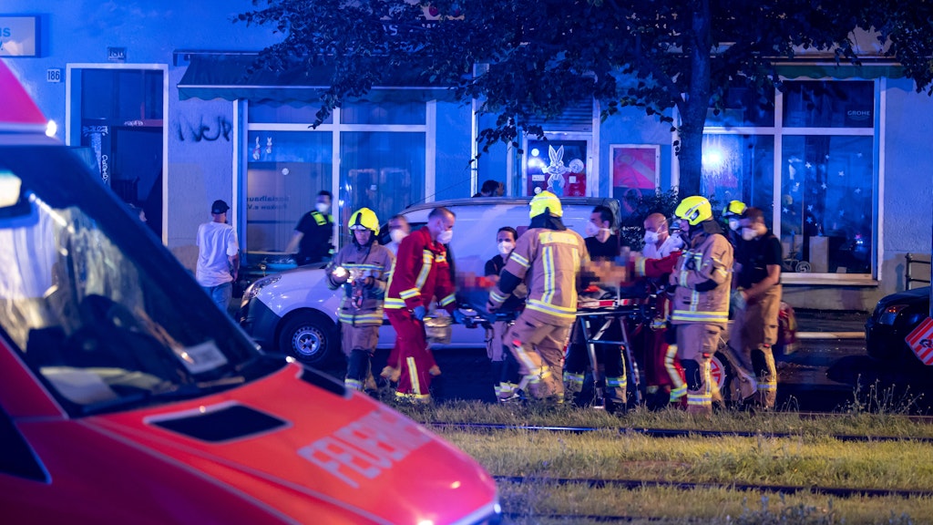 Ein Verletzter wird mit einer Trage zum Krankenwagen transportiert.