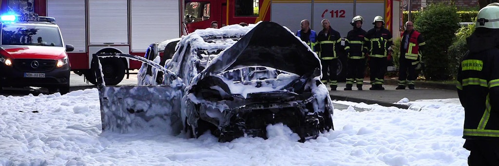  Vom Löschschaum bedeckt steht ein Auto nach der Explosion auf der Straße in Köln-Hürth.