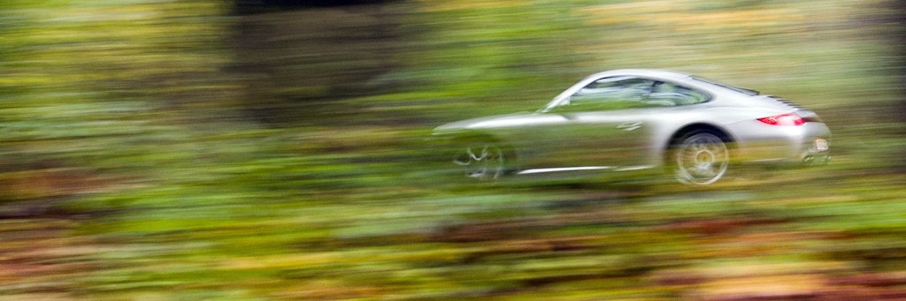 Ein Porsche fährt über eine Landstraße – hoffentlich hält sich der Fahrer an ein paar Verkehrsregeln.