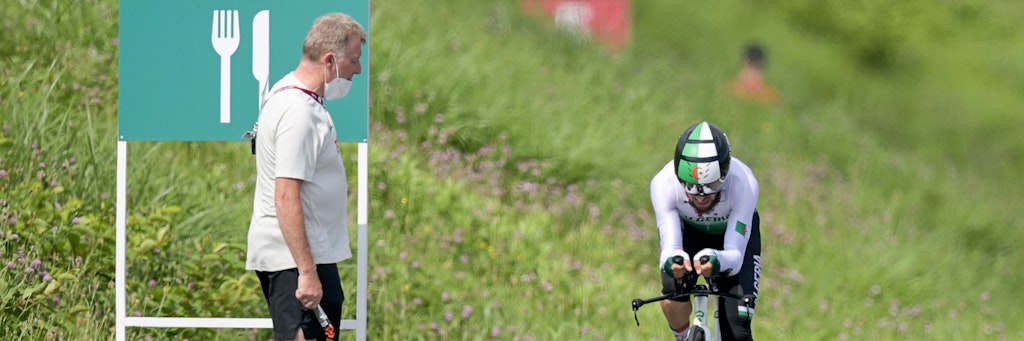Patrick Moster, Sportdirektor vom BDR (Bund Deutscher Radfahrer), steht am Streckenrand neben Azzedine Lagab aus Algerien in Aktion beim Zeitfahren. 