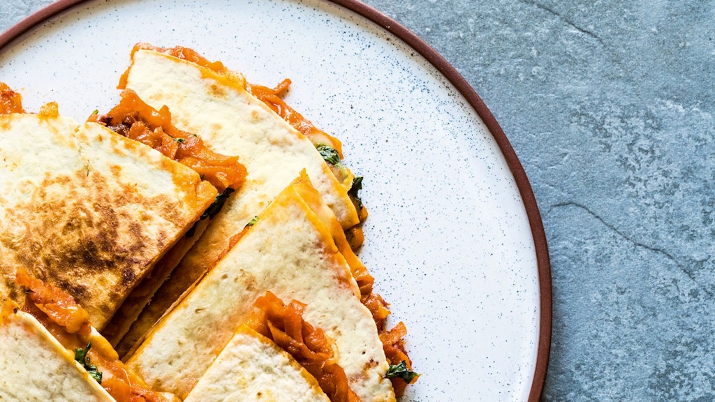 Für die Quesadillas wird der Fladen erwärmt, mit Käse bestreut, gefüllt - etwa wie hier auch mit Süßkartoffel - und dann komplett zugeklappt. 