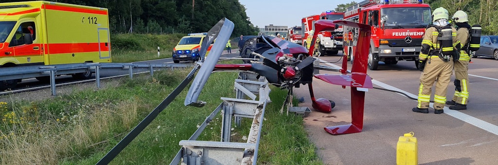 Einsatzkräfte der Feuerwehr stehen an der Absturzstelle.