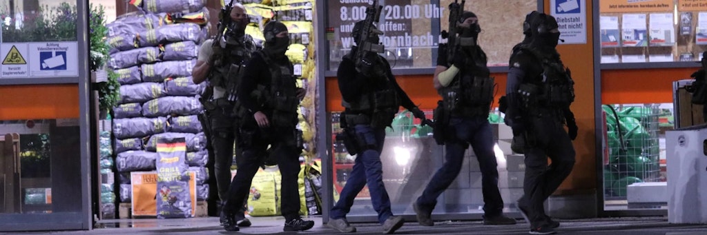 Schwerbewaffnete Polizisten durchsuchen das Gelände des Baumarkts.