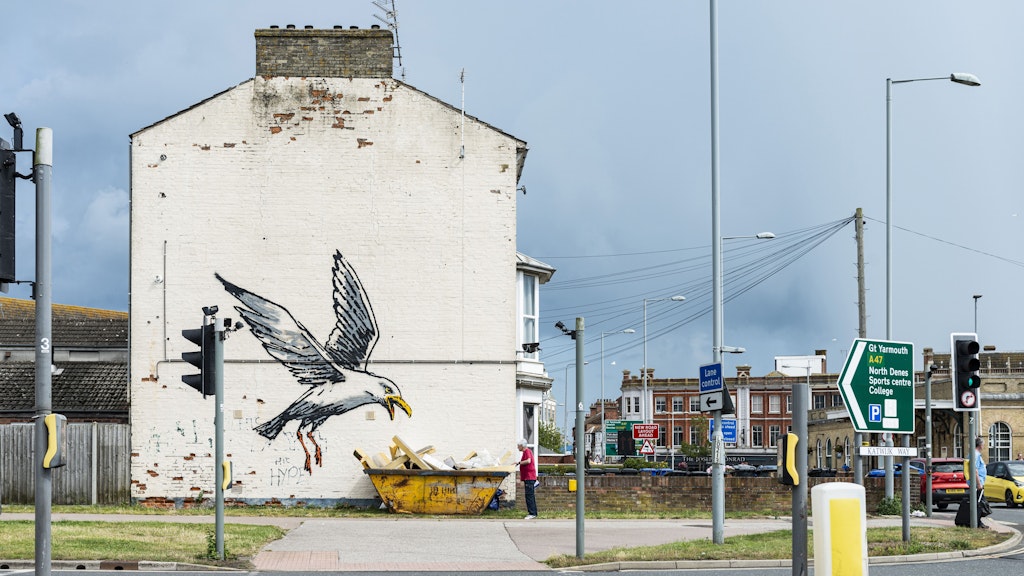 Eine hungrige Möwe landet an der Seite eines Hauses in Lowestoft.