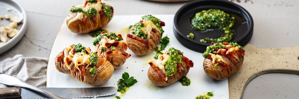 Gefächert, gefüllt und garniert: Mit Kartoffeln im sogenannten Hasselback-Style mit Speck-Scheiben lässt sich auf dem Esstisch Eindruck schinden. 